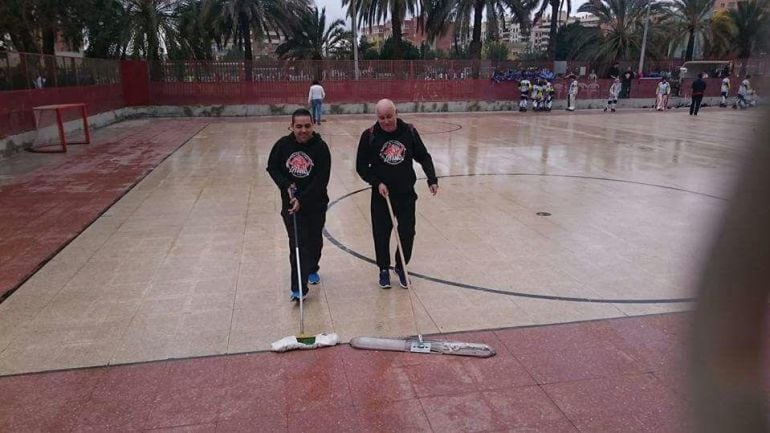 Miembros del Club de Patinaje Elche secando la pista tras la lluvia