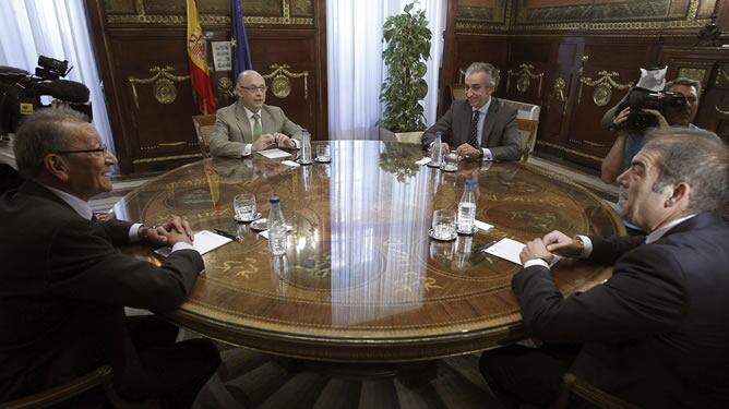 El ministro de Hacienda y Administraciones Públicas, Cristóbal Montoro (2i), durante la reunión que ha mantenido hoy con el presidente de la Asociación de Trabajadores Autonómos (ATA), Lorenzo Amor (d), y el secretario general de la Unión de Profesionales