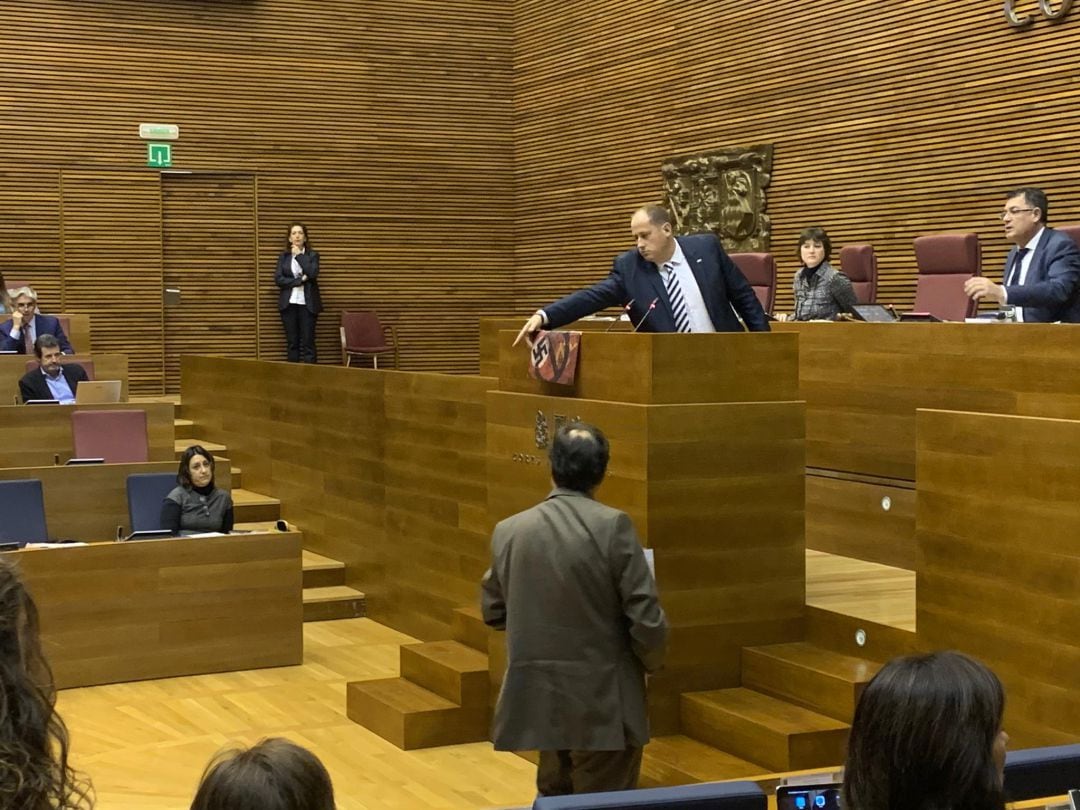 El diputado de Vox David García ha lucido el cartel en la tribuna en una sesión de pleno que ha indignado a otros diputados