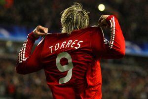 Fernando Torres señala las líneas rojas y blancas de la camiseta del Liverpool