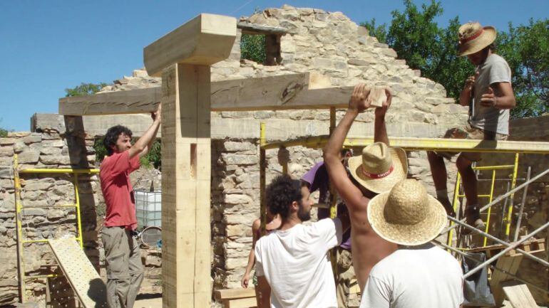 Los jóvenes del Colectivo Fraguas en plena reconstrucción de una de las casas.