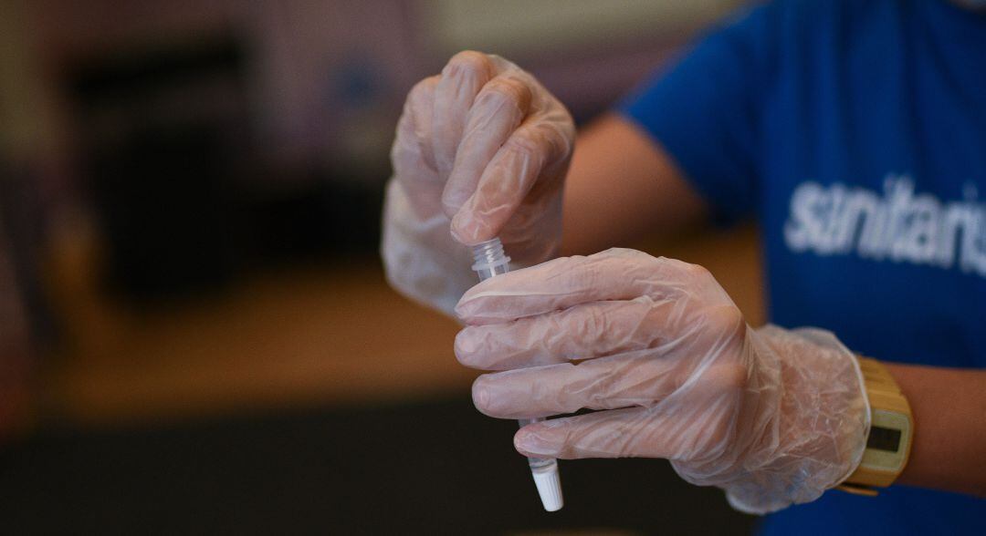 Una trabajadora guarda un test de antígenos.
