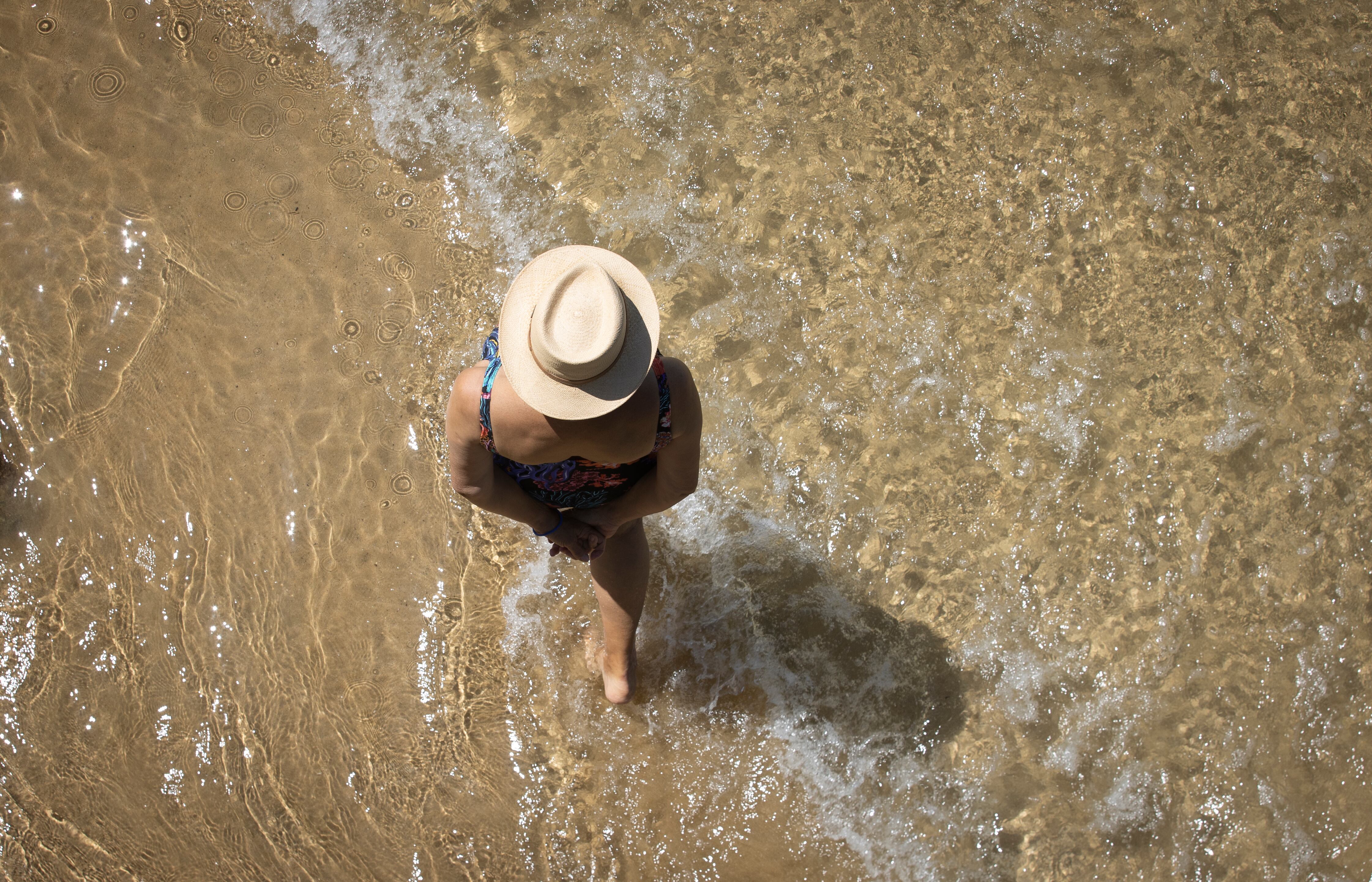 Una mujer pasea por la orilla de la playa de La Concha de San Sebastián