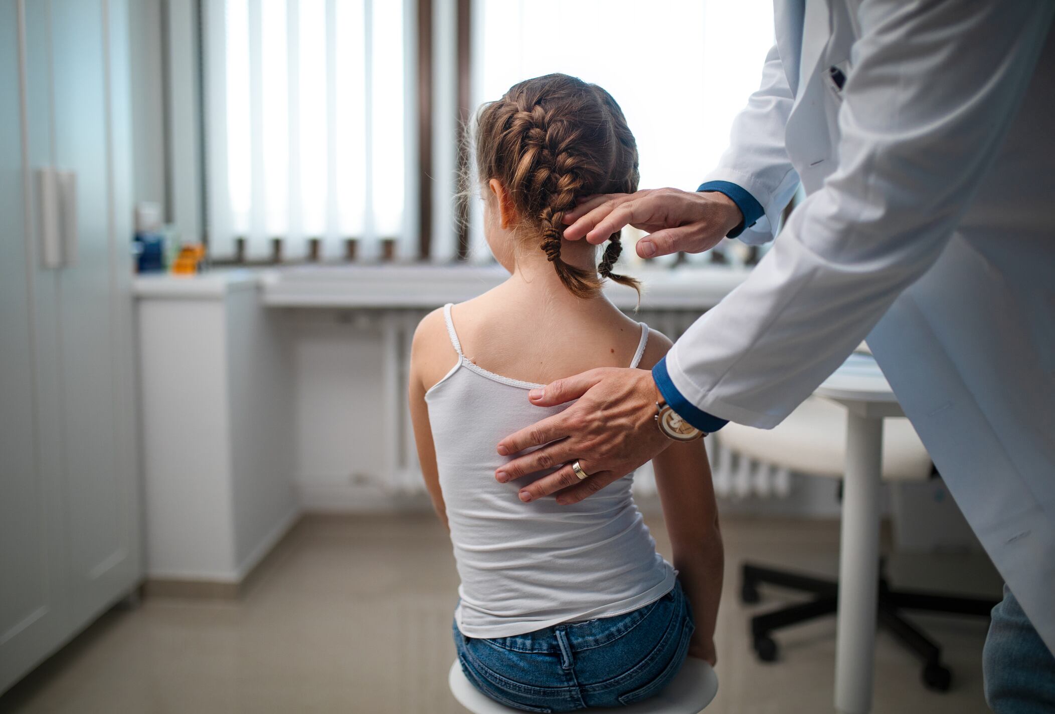 Un pediatra examina a una niña pequeña