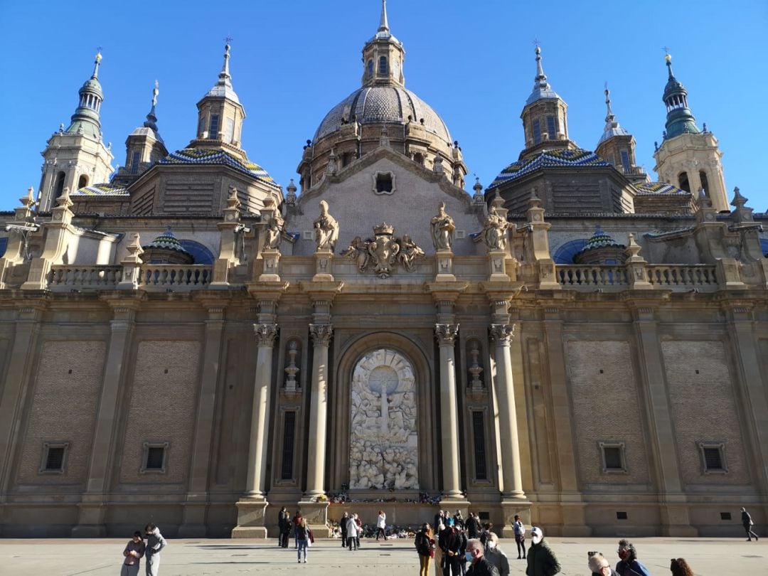 Algunos fieles han depositado flores a la Virgen del Pilar en la imagen del escultor Pablo Serrano de la Basílica del Pilar 