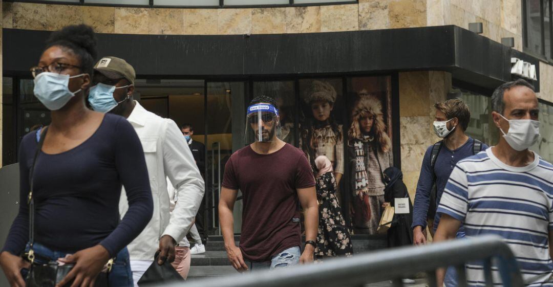 Personas paseando por la calle con medidas de protección contra el virus. EFE.
