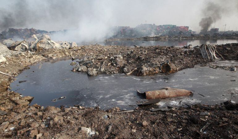 Un charco de líquido se eleva en los contenedores dañados en el lugar de las explosiones de Tianjin.