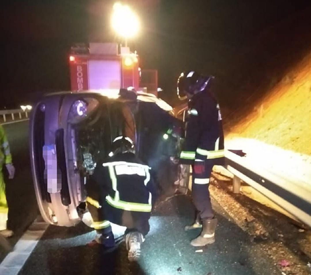 Los efectivos del parque de bomberos de Aranda durante los trabajos en el vehículo siniestrado.