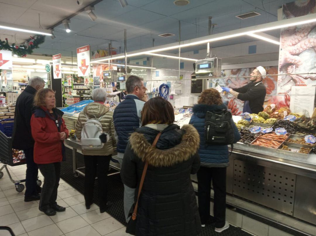 Gent esperant el torn per comprar el peix i marisc.