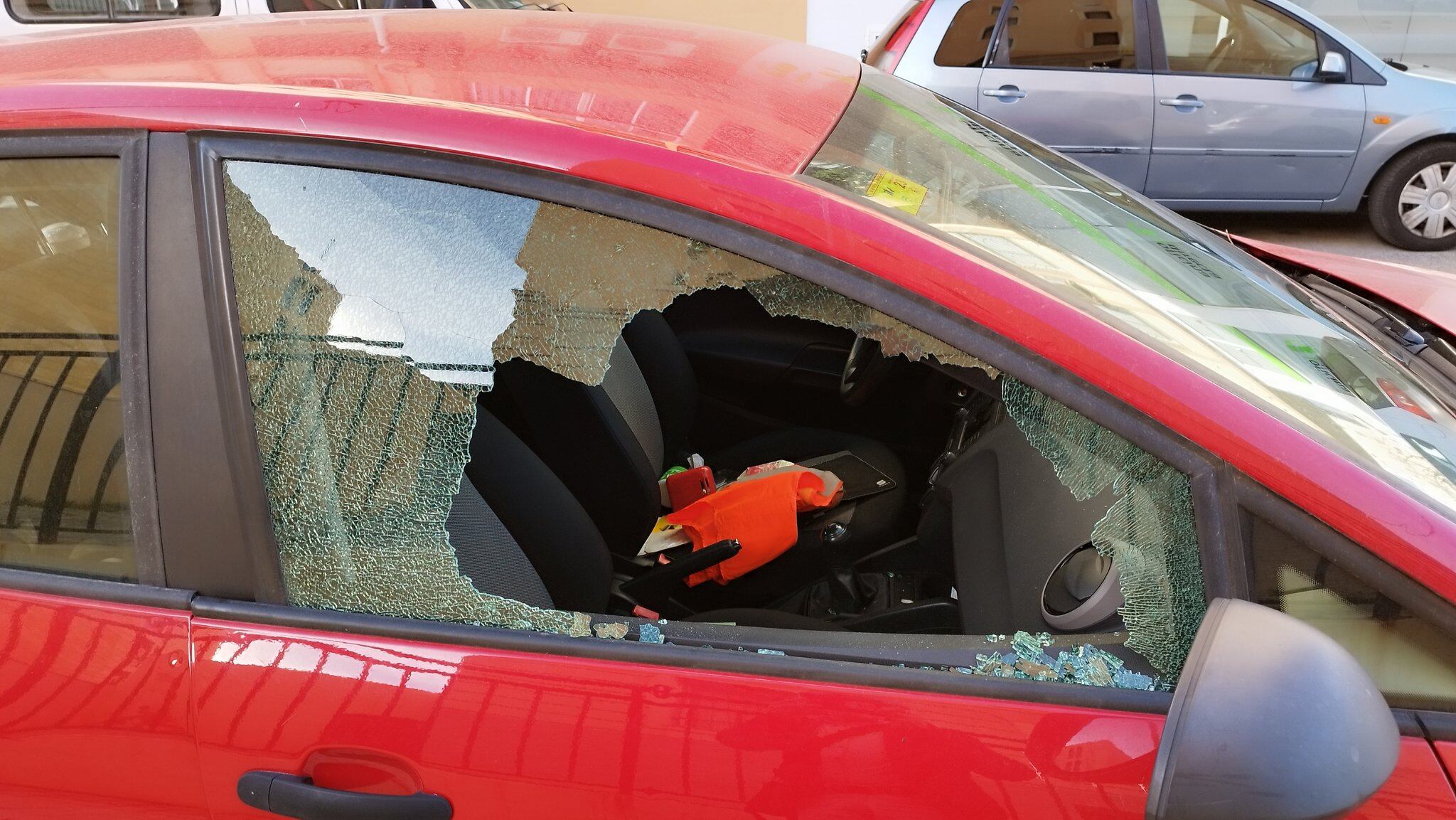 Uno de los vehículos con la ventana destrozada