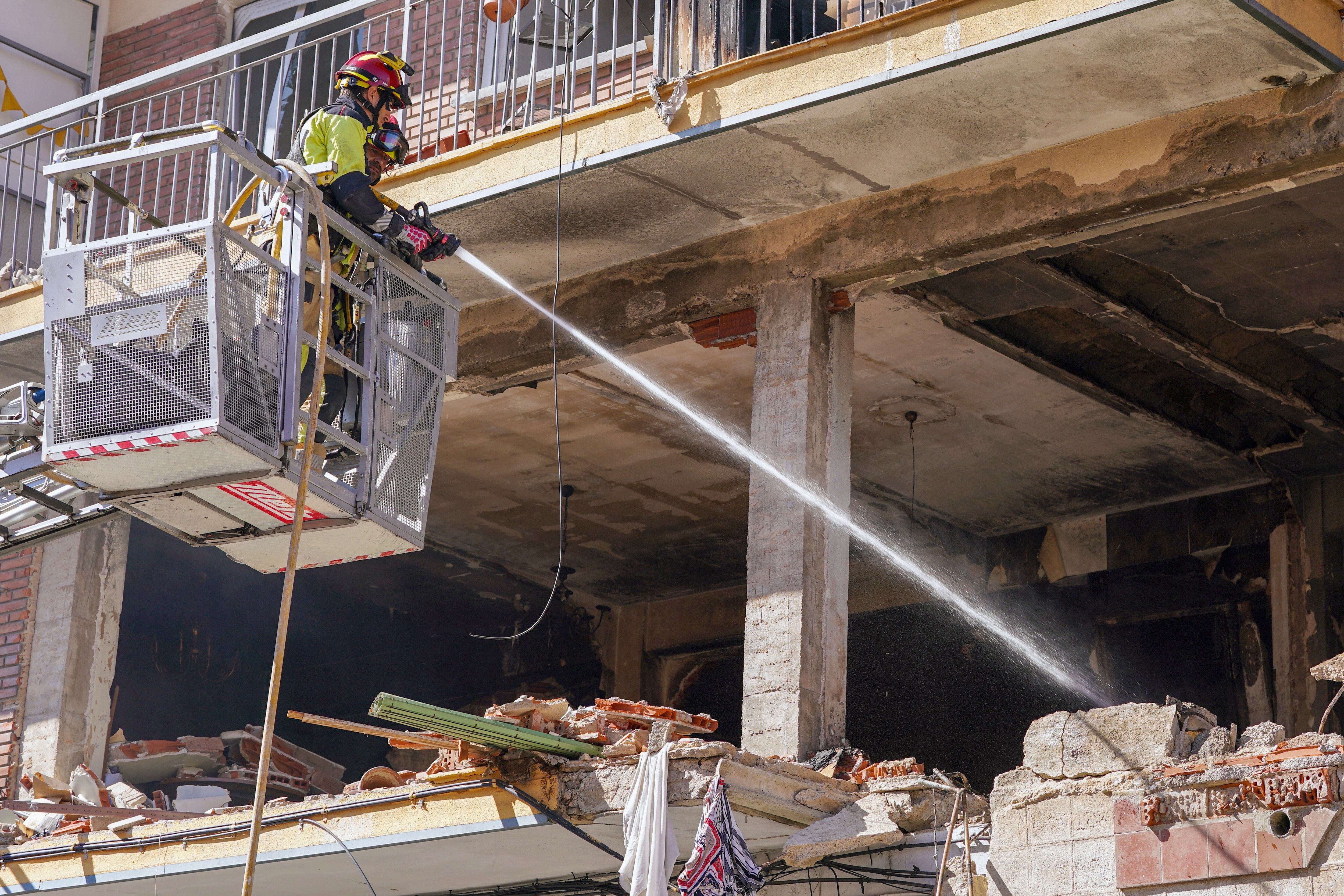 Efectivos de bomberos refrescan la zona mientras realizan labores de limpieza y desescombro en el edificio de la calle Goya en Valladolid,  tras la explosión mortal registrada anoche en el inmueble.