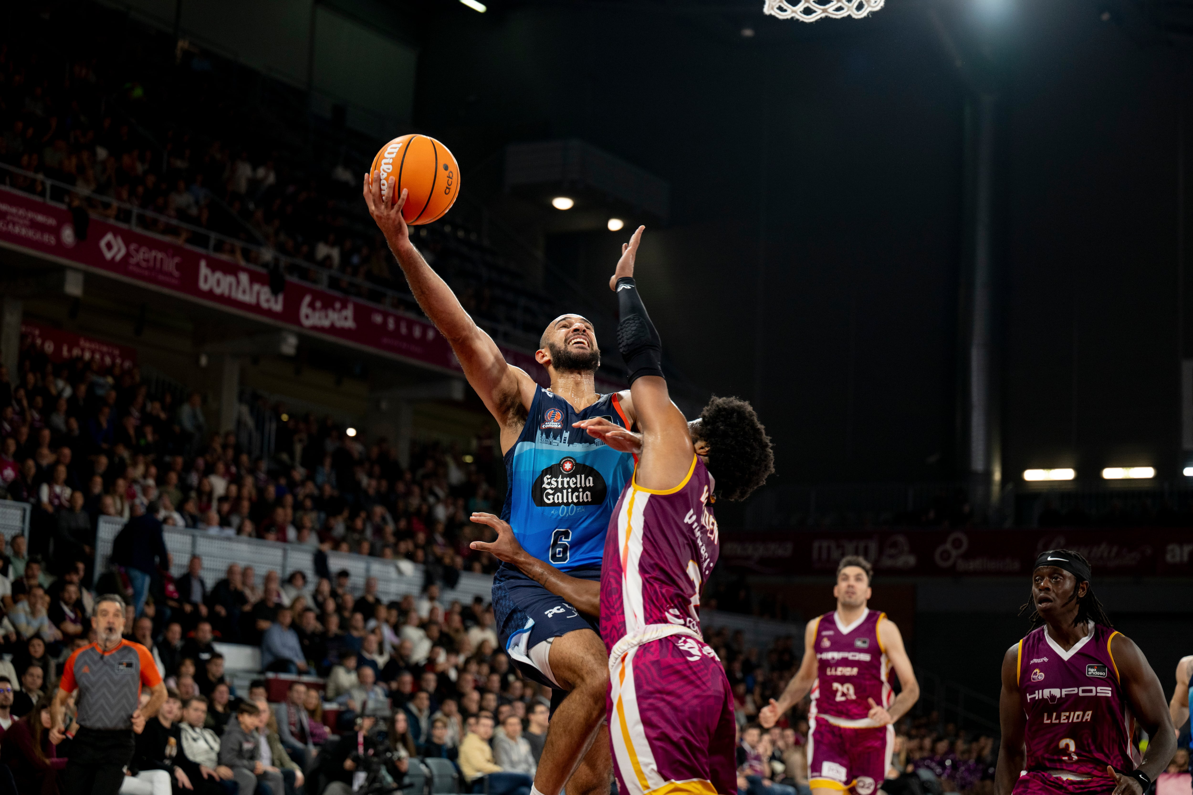 LLEIDA, 01/12/2024.- El escolta canadiense del Leyma Coruña Phil Scrubb (i) lanza ante el base estadounidense del Hiopos Lleida Corey Walden, en el partido de Liga Endesa que se disputa este domingo en el pabellón Barris Nord. EFE/ Alex López
