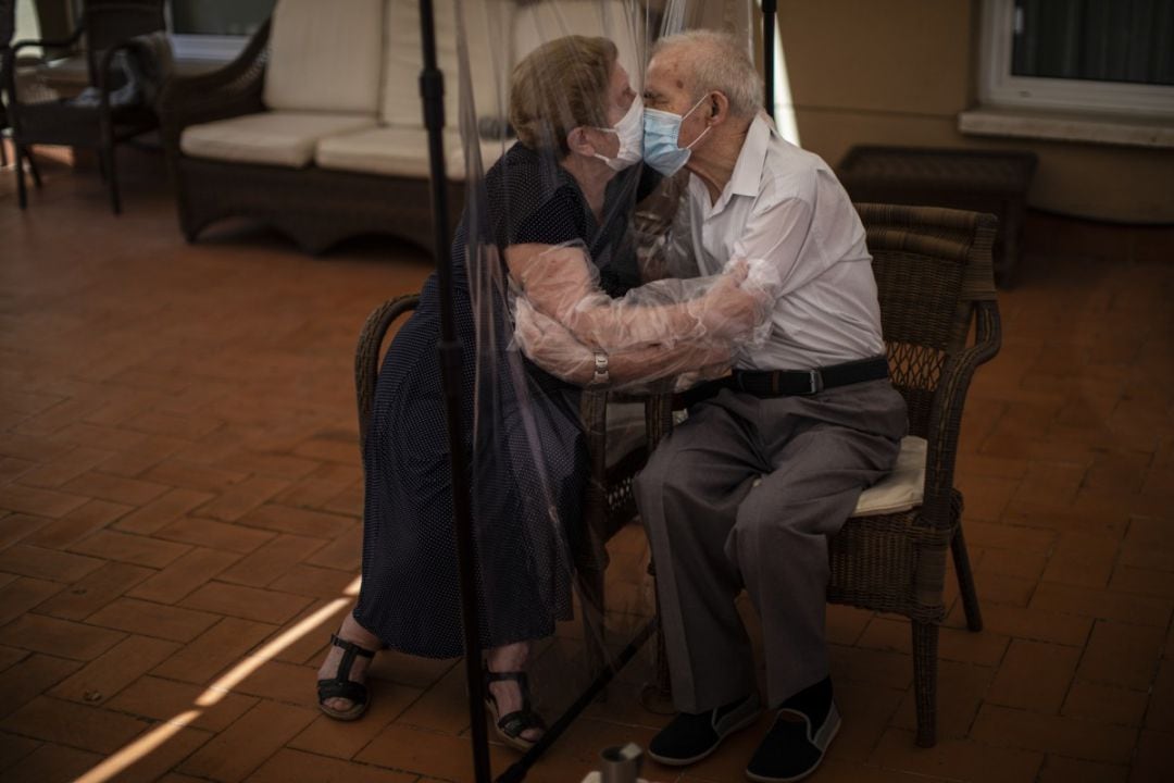 Agustina Canamero (81 años) y Pascual Pérez (84 años) se besan a través de una membrana de plástico para evitar el coronavirus en una residencia de Barcelona el pasado mes de junio de 2020