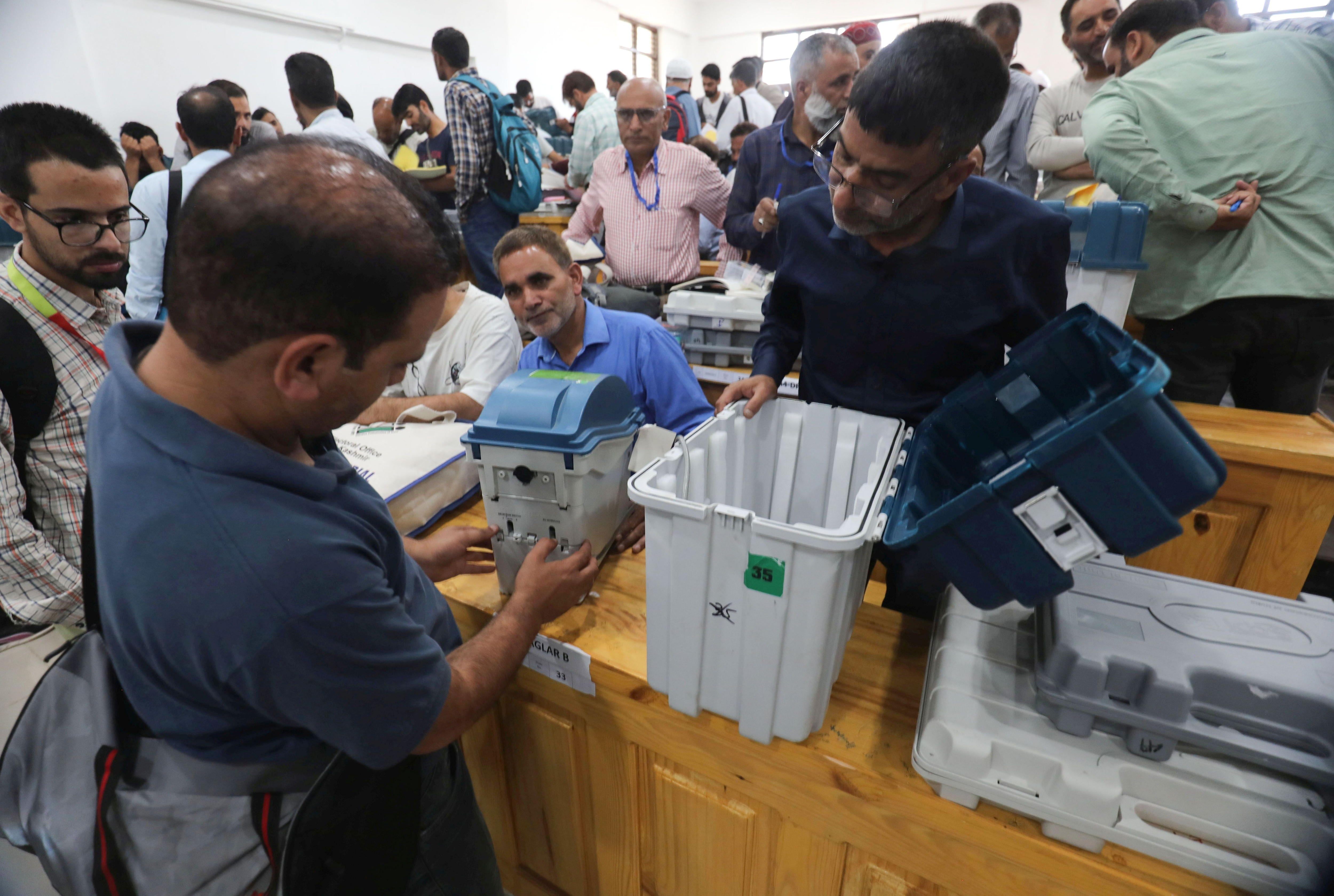 Oficiales comprobando las máquinas de votación electrónicas en la víspera de las votaciones