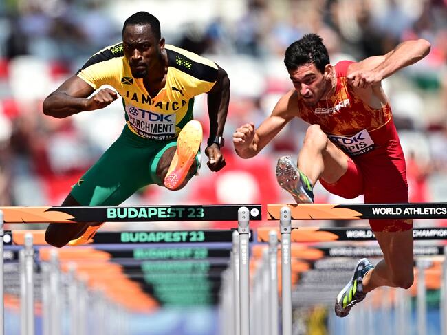 Budapest (Hungary), 20/08/2023.- Hansle Parchment of Jamaica (L) and Enrique Llopis of Spain (R) in action during a 110 Metres Hurdles Men heat of the World Athletics Championships in Budapest, Hungary, 20 August 2023. (Mundial de Atletismo, Hungría, España) EFE/EPA/CHRISTIAN BRUNA