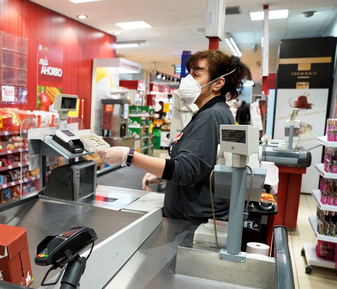 Empleado con mascarilla por coronavirus de los supermercados Dia