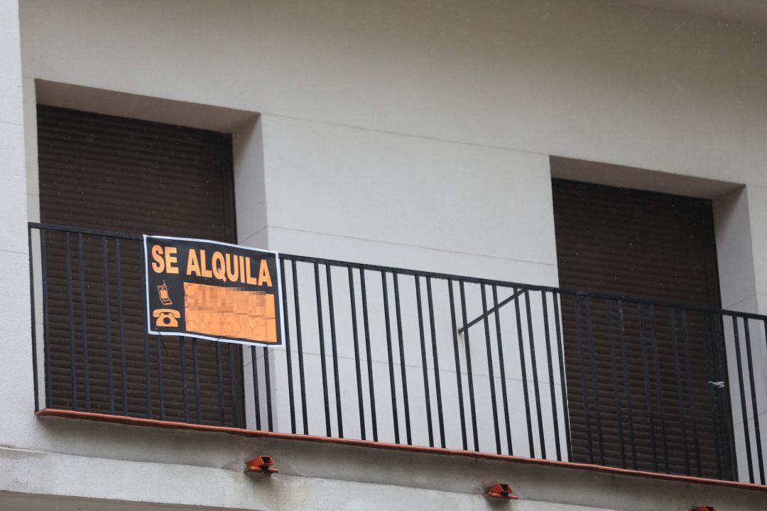 Cartel en una terraza que anuncia el alquiler de una casa