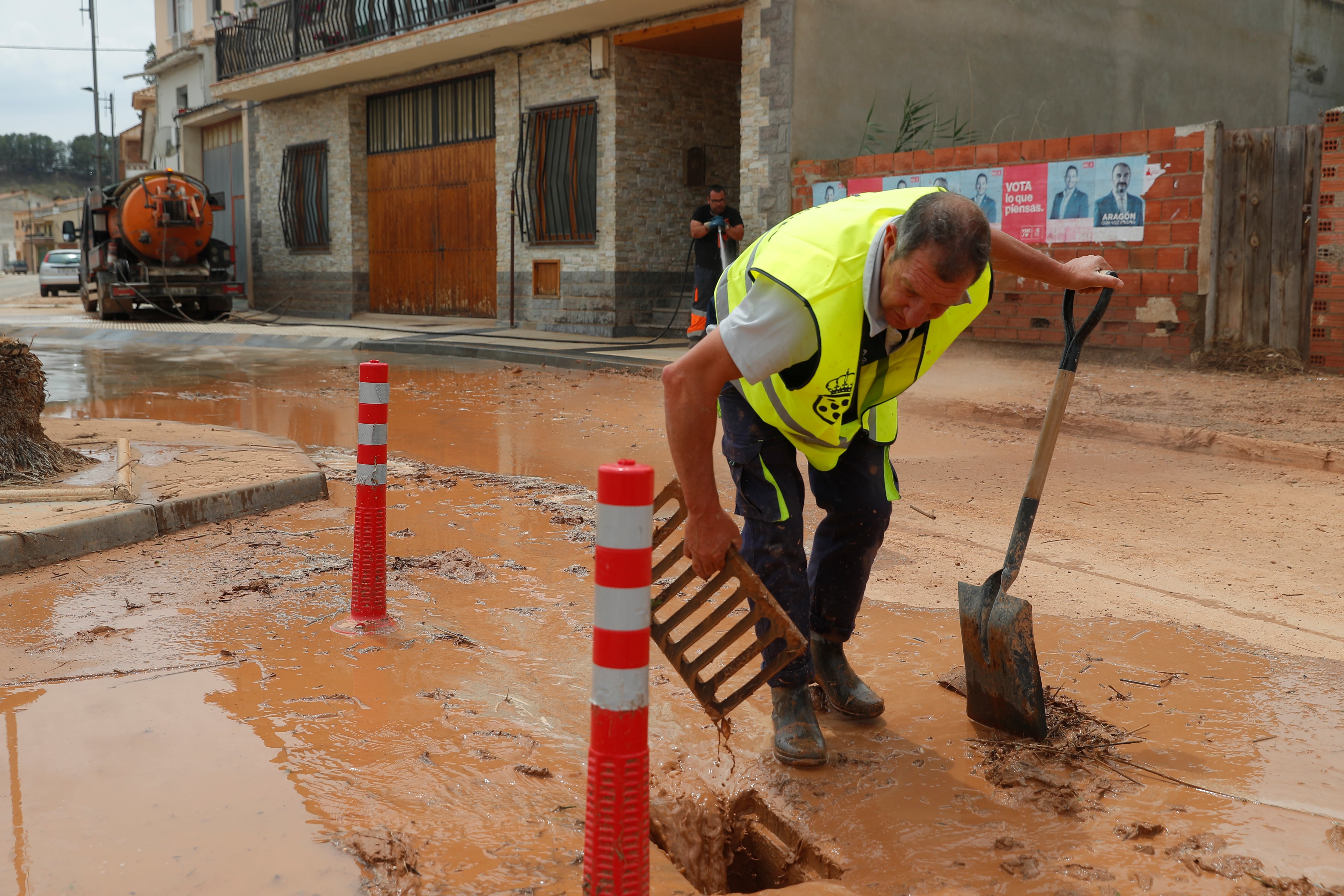 Limpieza de barro en la localidad zaragozana de Quinto de Ebro. Una fuerte tromba de agua caída este sábado por la tarde dejó 60 litros por metro cuadrado con intensidades torrenciales de 30 litros en solo diez minutos en la localidad zaragozana de Quinto y provocó inundaciones en los bajos de varios edificios y garajes.