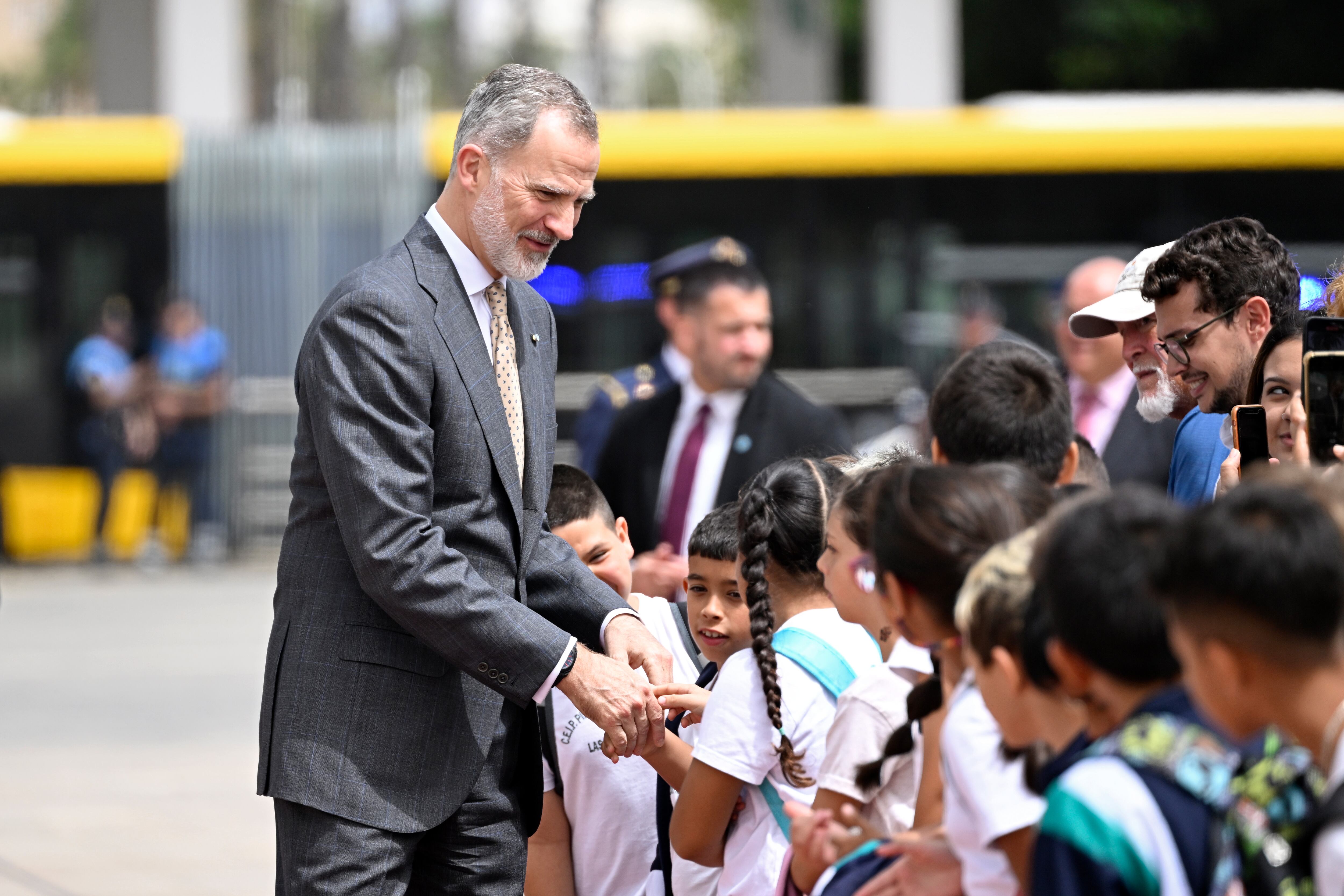 El rey Felipe VI saluda a un grupo de niños.