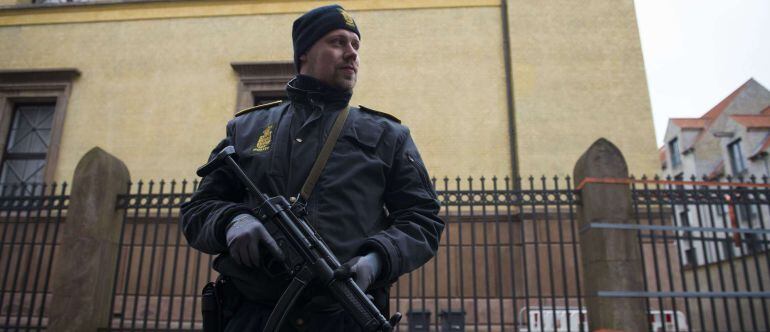 A police officer stands guard outside the synagogue Krystalgade in Copenhagen, on February 15, 2015 after two fatal attacks in the Danish capital, at a cultural center during a debate on Islam and free speech and a second outside the city&#039;s main synagogue