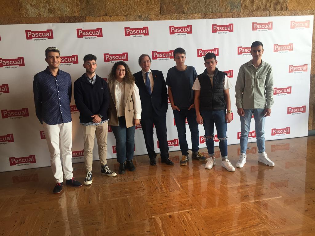 Seis de los jóvenes becados posan con el presidente de la compañía