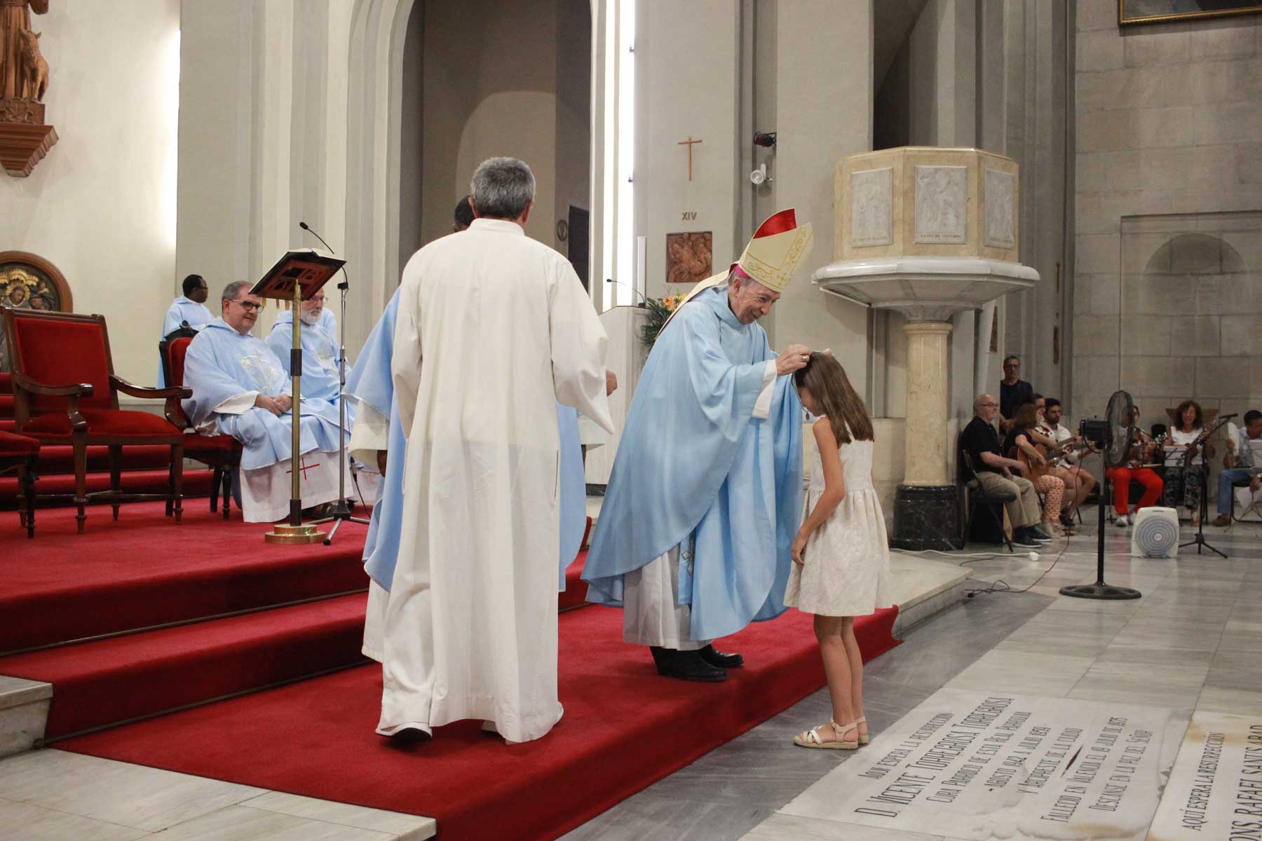 Una de las jóvenes asistentes a la misa que se acercó a recibir su medalla de la Virgen