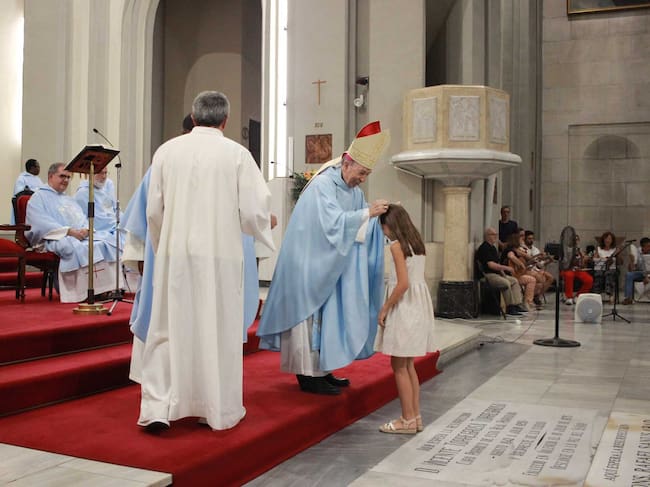 Una de las jóvenes asistentes a la misa que se acercó a recibir su medalla de la Virgen