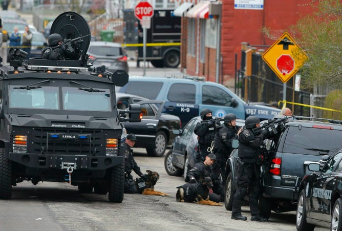 Un grupo de policías fuertemente armados y sus perros toman posiciones