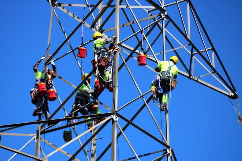 Operaris descargolant els claus que aguanten part de la torre de 220 kV