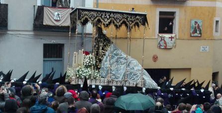 La Soledad de San Agustín, con el manto protegido por plásticos, a su paso por la calle del Peso.