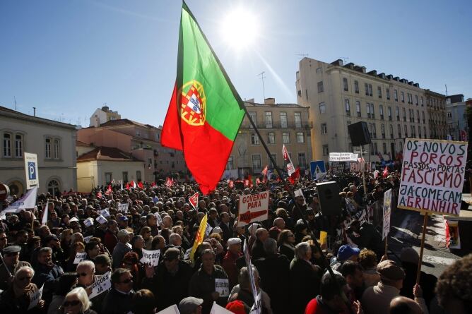 Un grupo de manifestantes muestra pancartas en las que se puede leer &#039;Gobierno fuera y elecciones YA&#039; durante unas protestas en contra de los recortes aprobados en el Parlamento