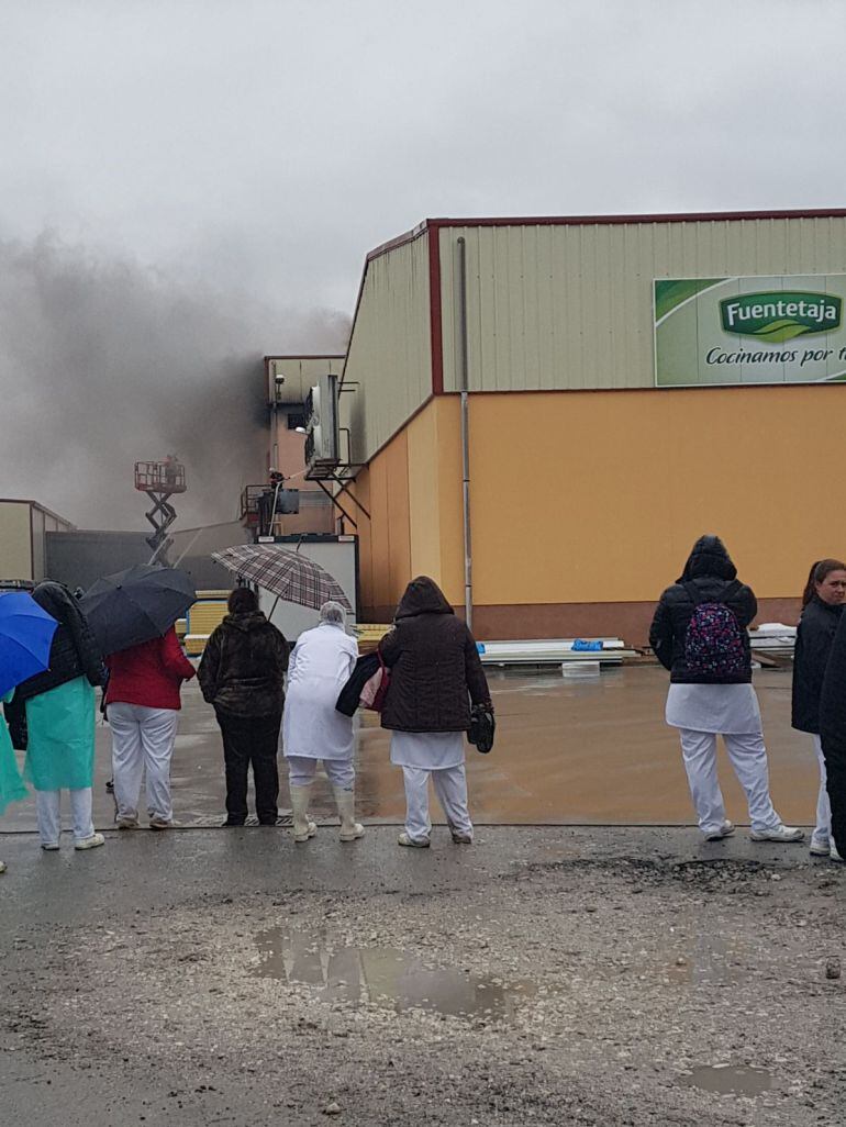 Los trabajadores observan la actuación de los bomberos