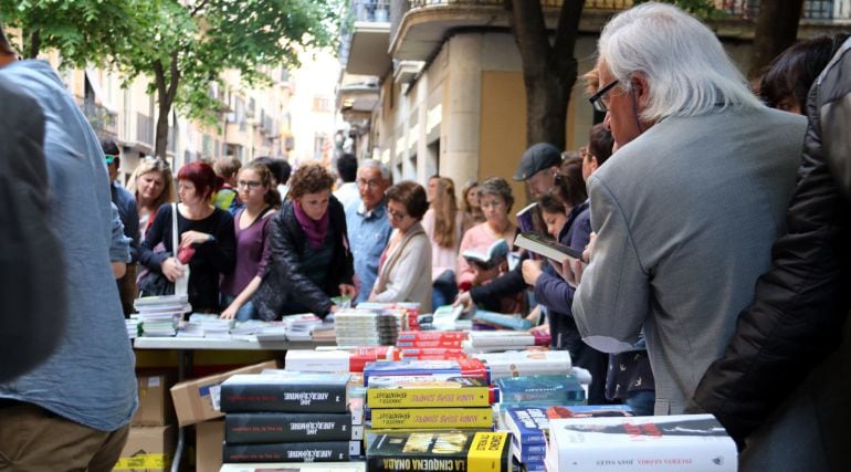 Algunos lectores hojean libros este domingo 23 de abril de 2017 en una de las paradas de la Rambla.