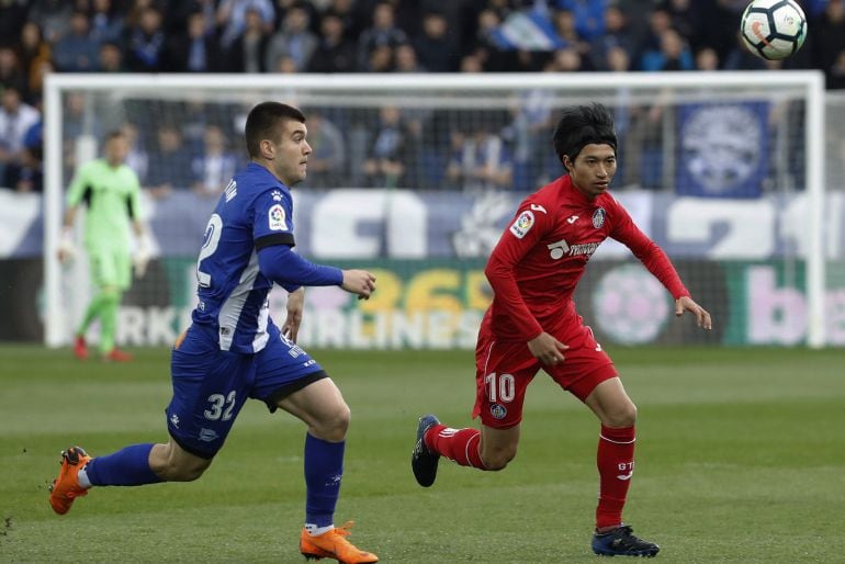 El centrocampista japonés del Getafe CF, Gaku Shibasaki, persigue un balón ante el defensa del Deportivo Alavés, Martin Aguirregabiria.