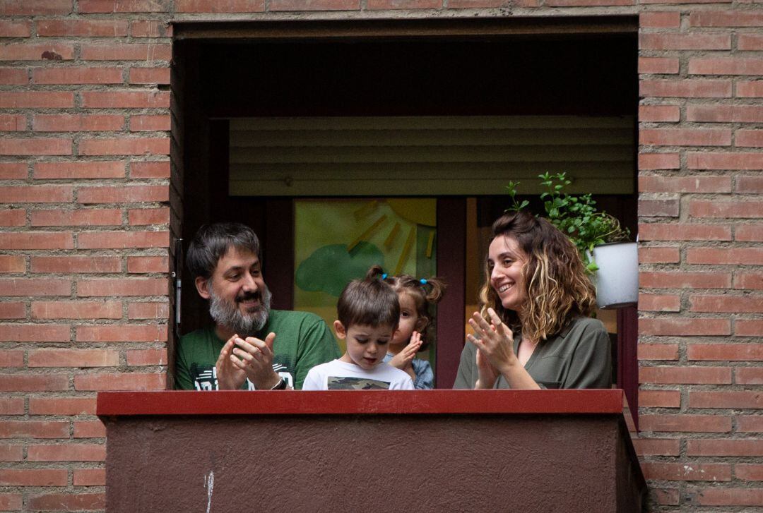 Una familia con niños aplaude desde su balcón en Madrid.