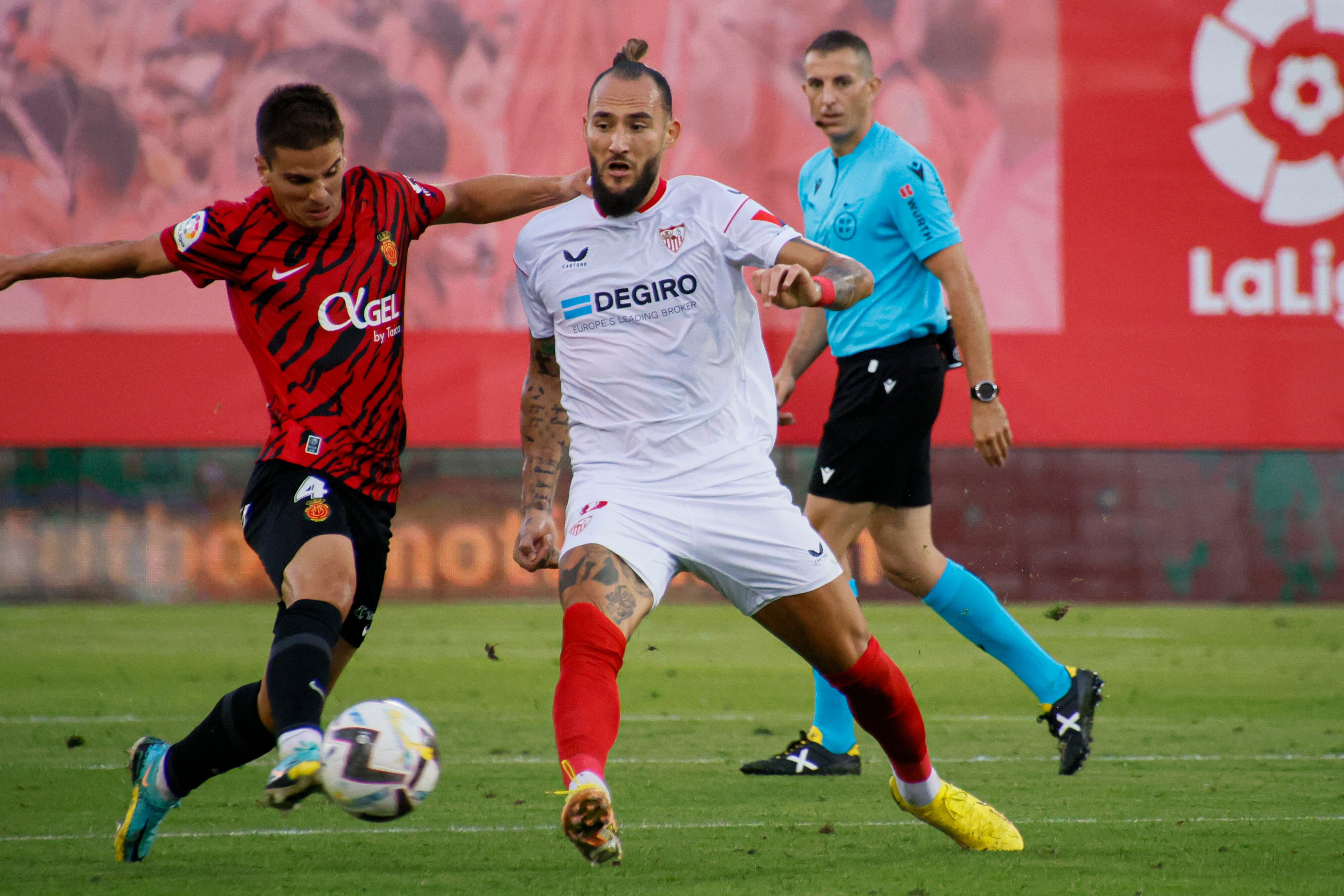 PALMA DE MALLORCA, 15/10/2022.- El centrocampista del Mallorca Ruiz de Galarreta (i) juega un balón ante Nemanja Gudelj, del Sevilla, durante el partido de Liga en Primera División que disputan este sábado en el Visit Mallorca Estadi. EFE/Cati Cladera
