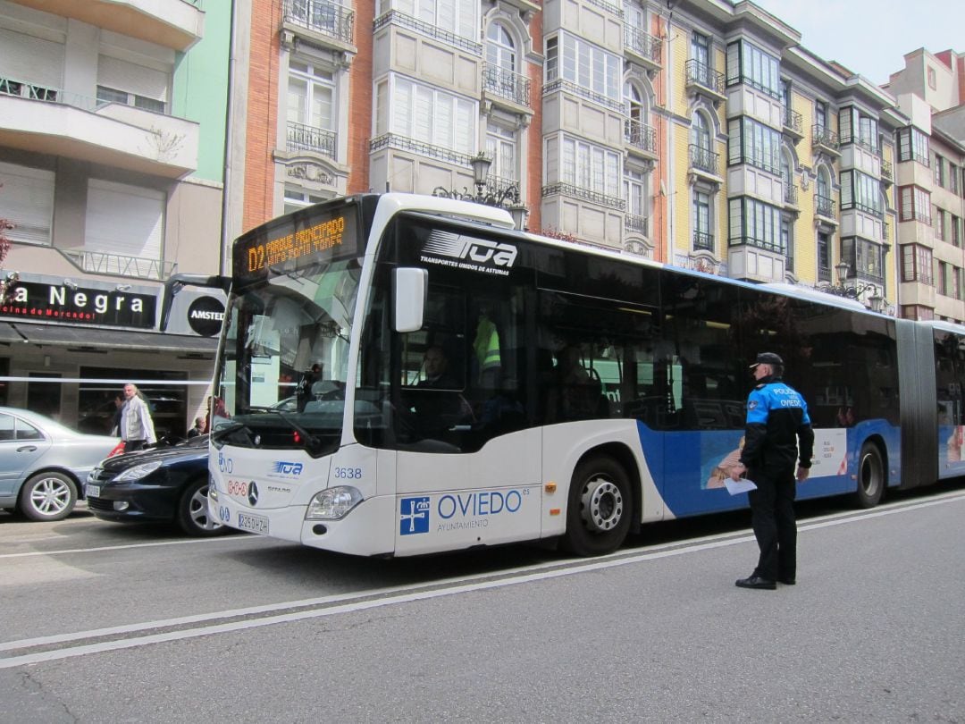 Un autobús de TUA circula por la avenida de Galicia en presencia de un agente de la Policía Local.