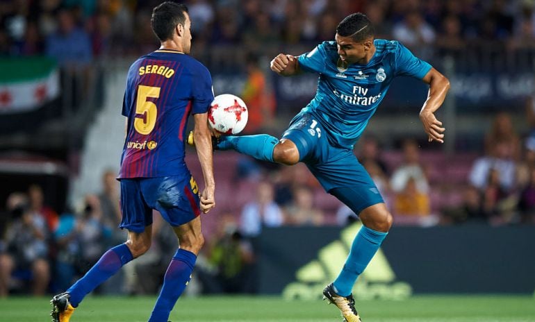 Casemiro despeja el balón y también el brazo de Busquets. Es uno de los duelos del partido