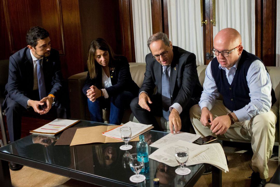 El presidente de la Generalitat, Quim Torra (c) junto a la consellera de la Presidencia, Meritxell Budó (2i) y el conseller de Territori Damià Calvet (i) , durante la reunión que ha mantenido en su despacho del Parlament con su abogado Carlos Boye (d), tras conocerse la decisión del Tribunal Superior de Justicia de Cataluña (TSJC) que le inhabilita un año y medio por negarse a retirar los lazos amarillos. 