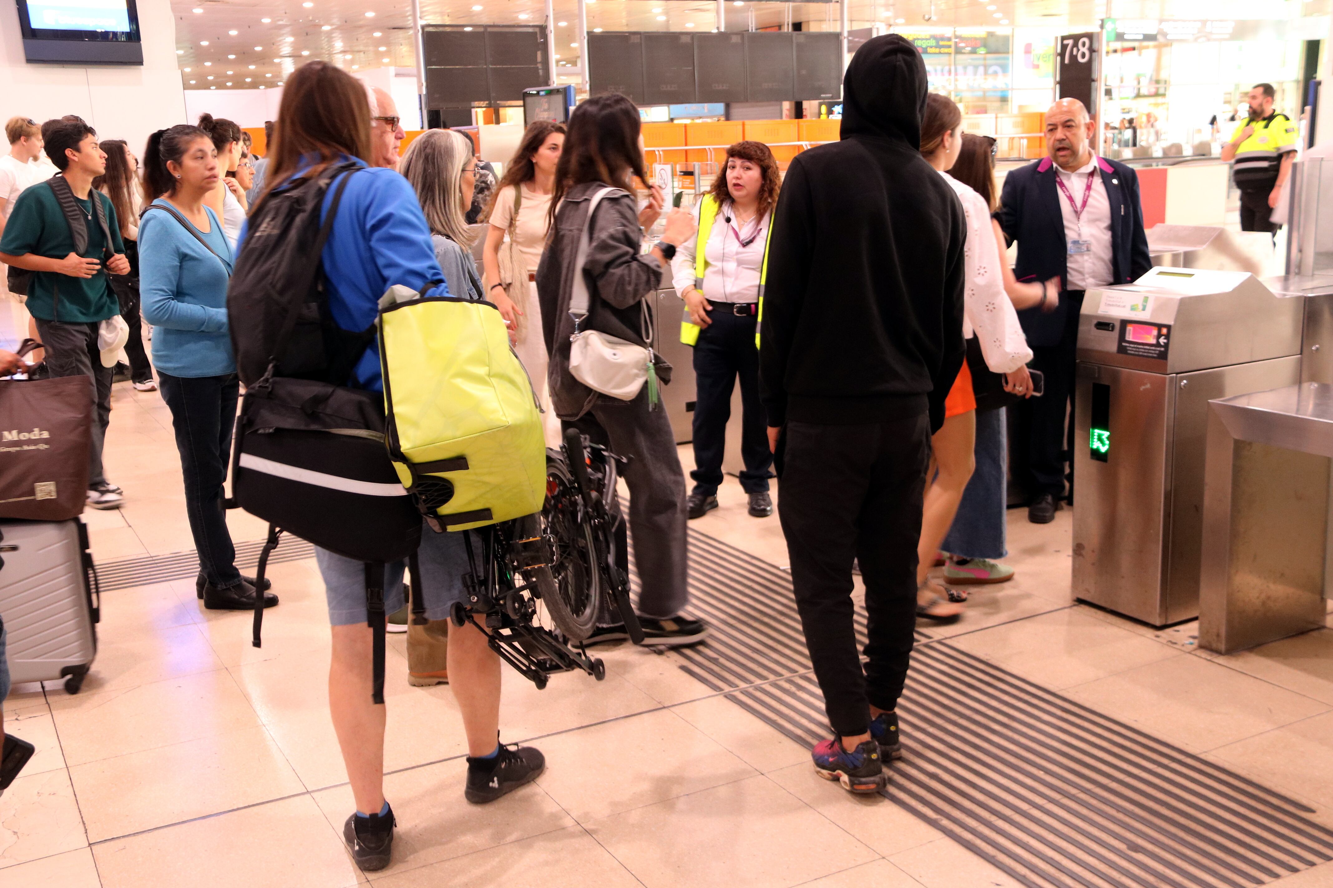 Usuaris esperant amb resignació la sortida d'algun tren de Rodalies a l'estació de Sants