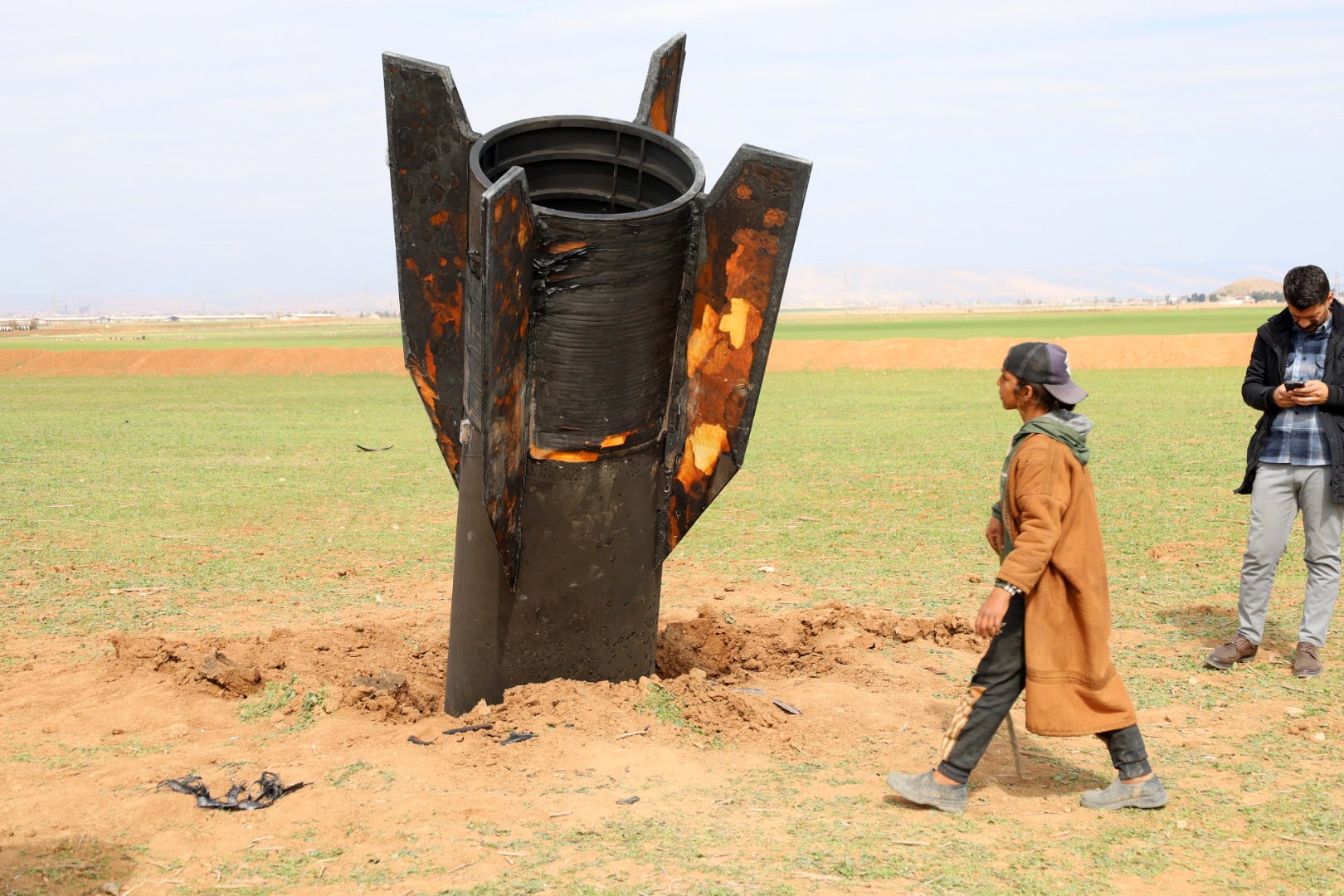 Personas observan un misil iraní que cayó en la aldea de Qazaljo, en la zona rural de Qamishli, Siria.