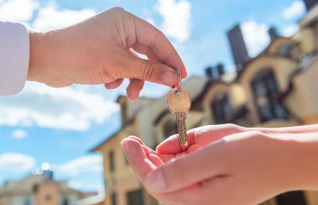 Imagen de un propietario entregando las llaves de una vivienda a otro