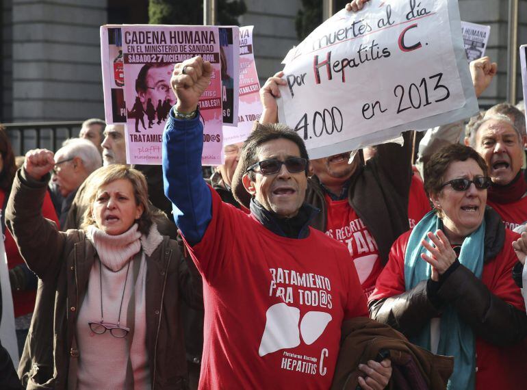 Varias personas participan en una cadena humana, organizada por la Plataforma de Afectados por la Hepatitis C, rodeando el Ministerio de Sanidad.