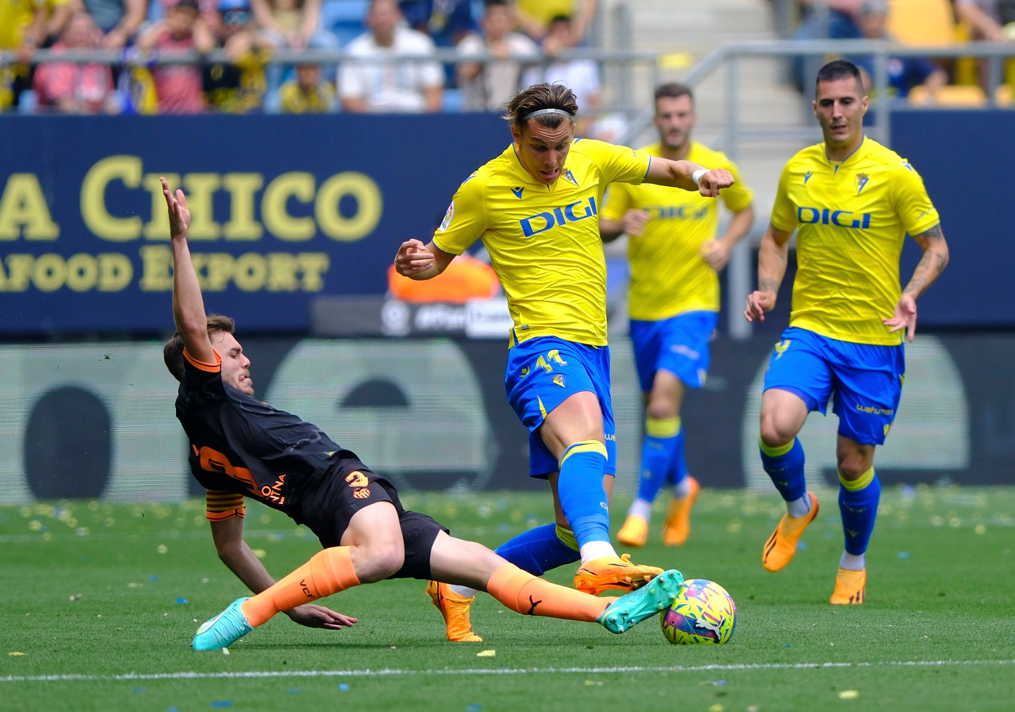 GRAF9793. CÁDIZ, 30/04/2023.- El jugador del Valencia CF Toni Lato (i) lucha por el balón con el jugador del Cádiz CF Iván Alejo, durante el partido de LaLiga que enfrentó al Cádiz CF y al Valencia CF este domingo en el Estadio Nuevo Mirandilla (Cádiz). EFE/Román Ríos