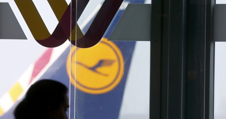 Una trabajadora pasa junto a logo de Germanwings y Lufthansa en el aeropuerto de Duesseldorf