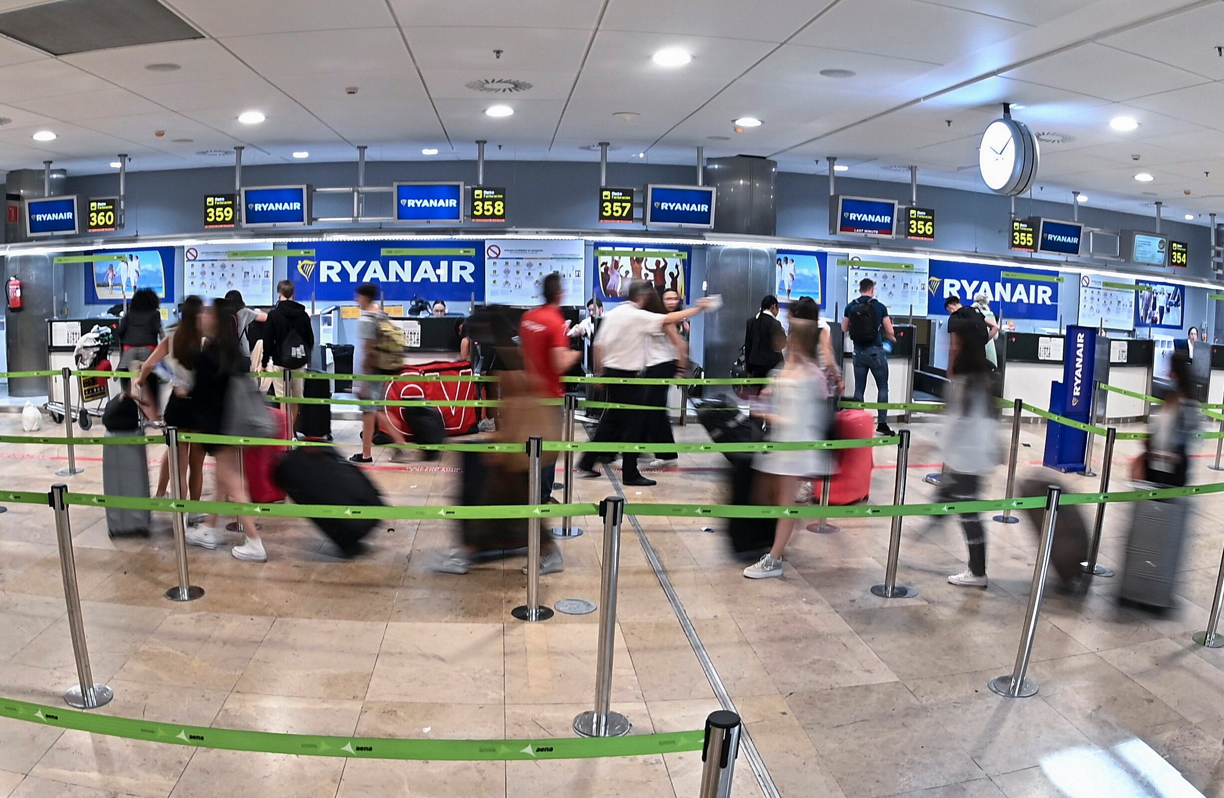 GRAF6909. MADRID, 24/06/2022.- Varias personas esperan para facturar en los puestos de Ryanair en el aeropuerto de Barajas este viernes en Madrid durante las primeras horas de la huelga en España de los tripulantes de la aerolínea irlandesa. EFE/ Fernando Villar