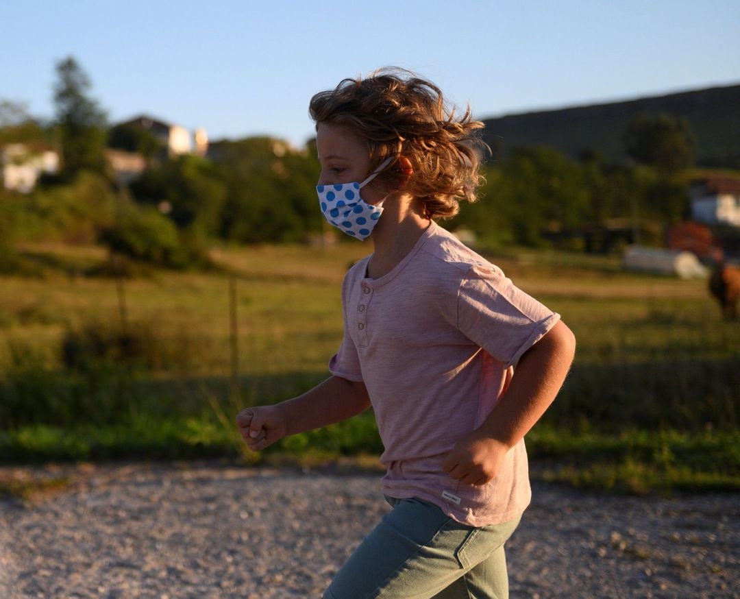 Un niño con mascarilla juega 