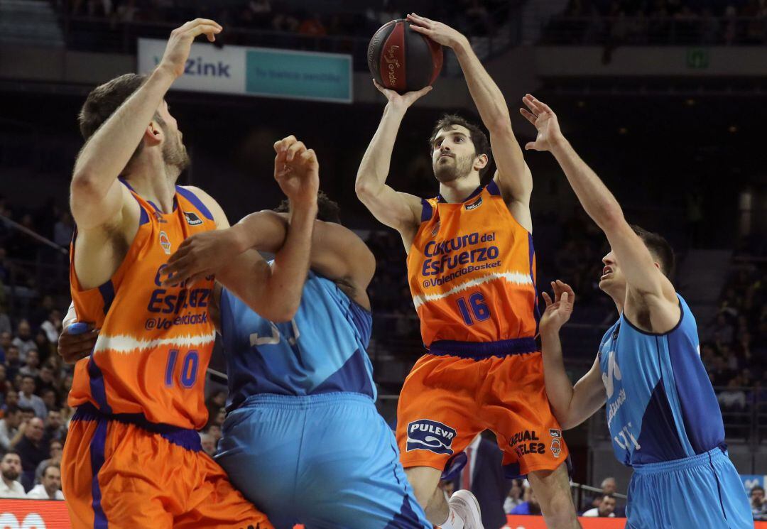 El base del Valencia Basket Guillem Vives (2d) lanza a canasta durante el partido de la Liga Endesa que Estudiantes y Valencia Basket disputan este domingo en el Wizink Center. 