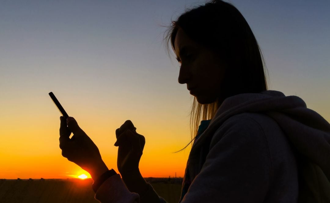 Una mujer utilizando su teléfono móvil.