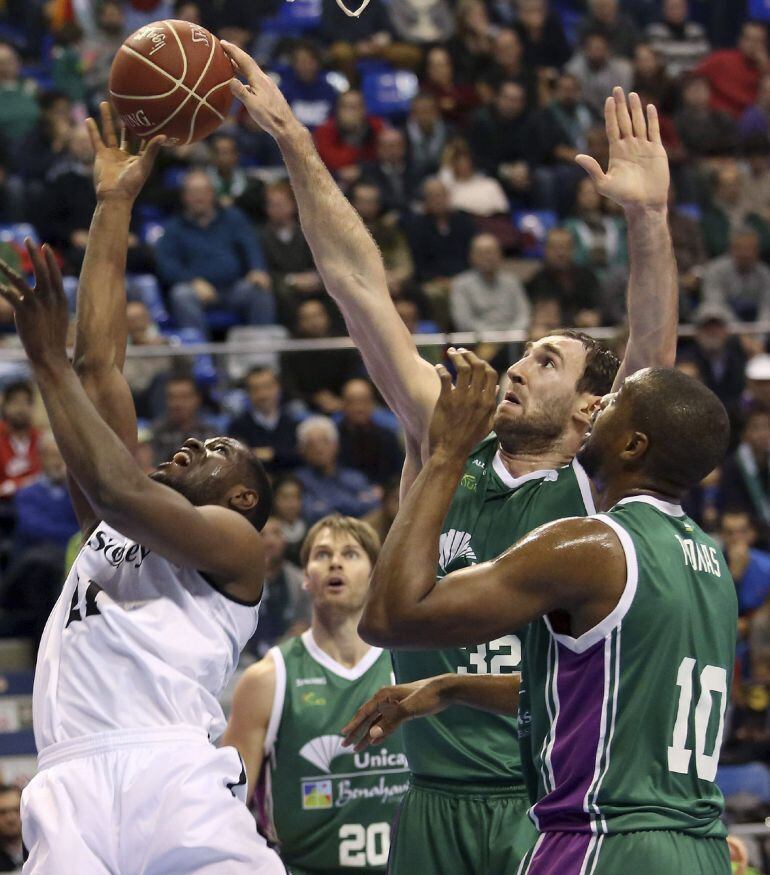 GRA226. MÁLAGA, 18/01/2015.- El pívot montenegrino del Unicaja, Vladimir Golubovic (2d), tapona al ala-pivot norteamericano del Bilbao Basket, Latavious Williams (i), durante el partido disputado esta noche en el pabellón José María Martín Carpena, perteneciente a la 17 jornada de la Liga Endesa. EFE/Carlos Díaz